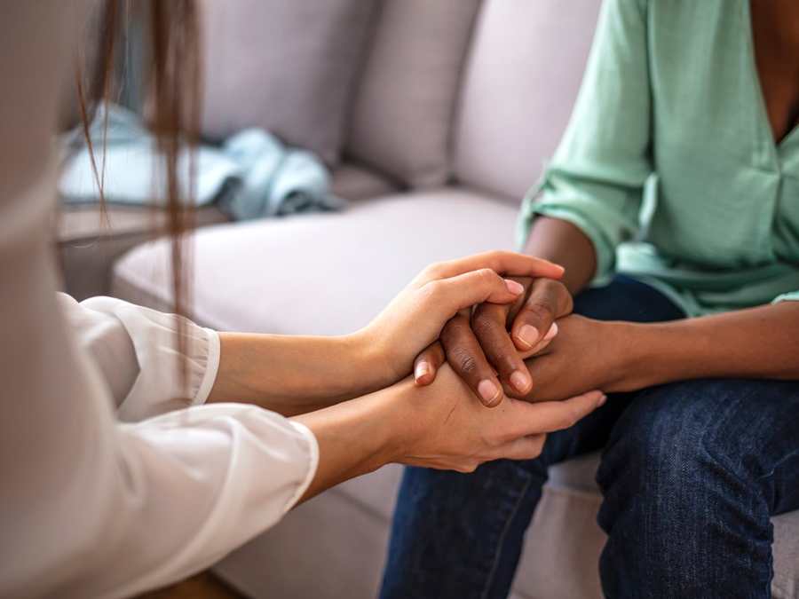 One person offering a reassuring hand to another